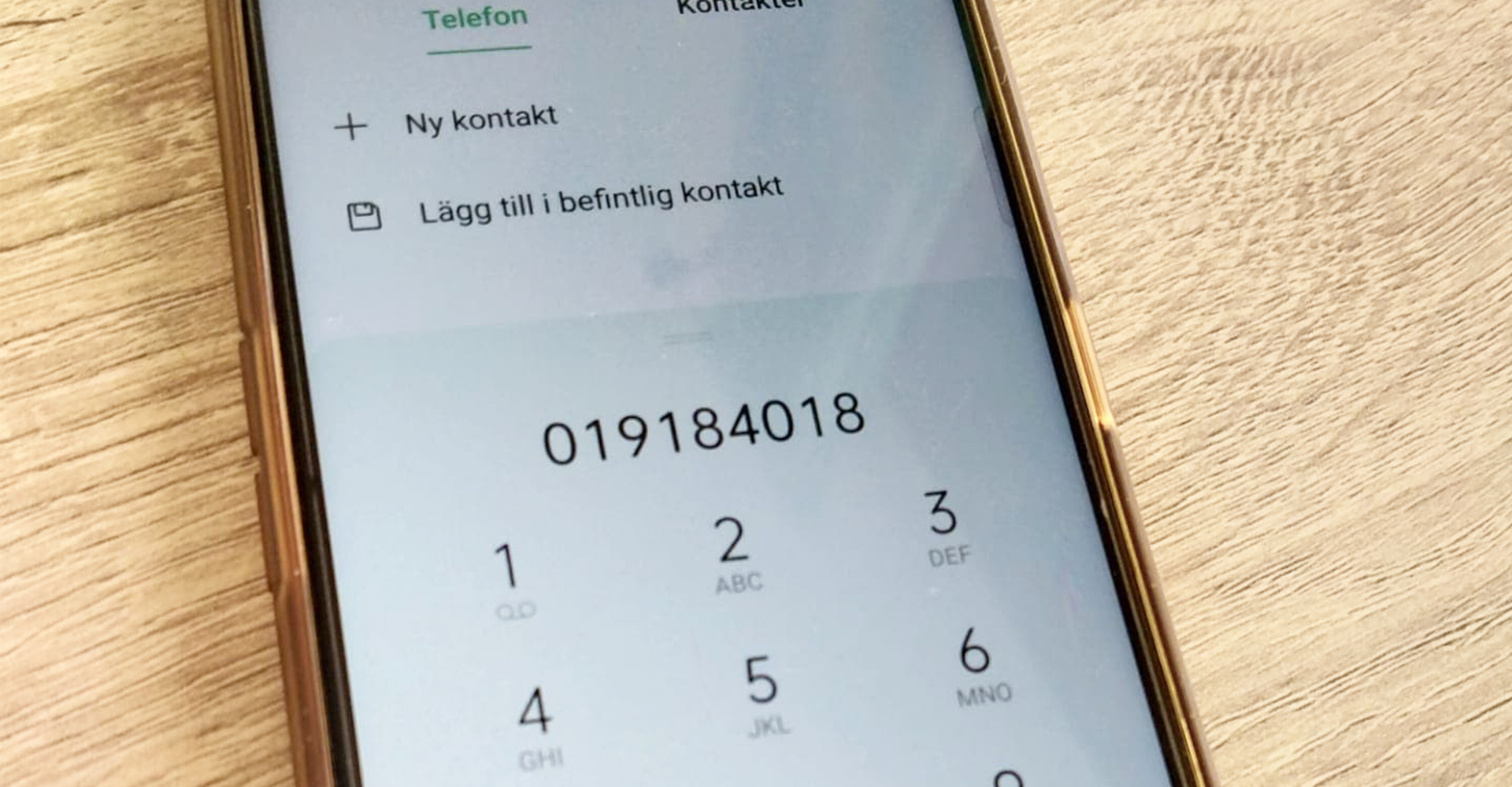 Närbild på telefon som slagit in numret 019-184018