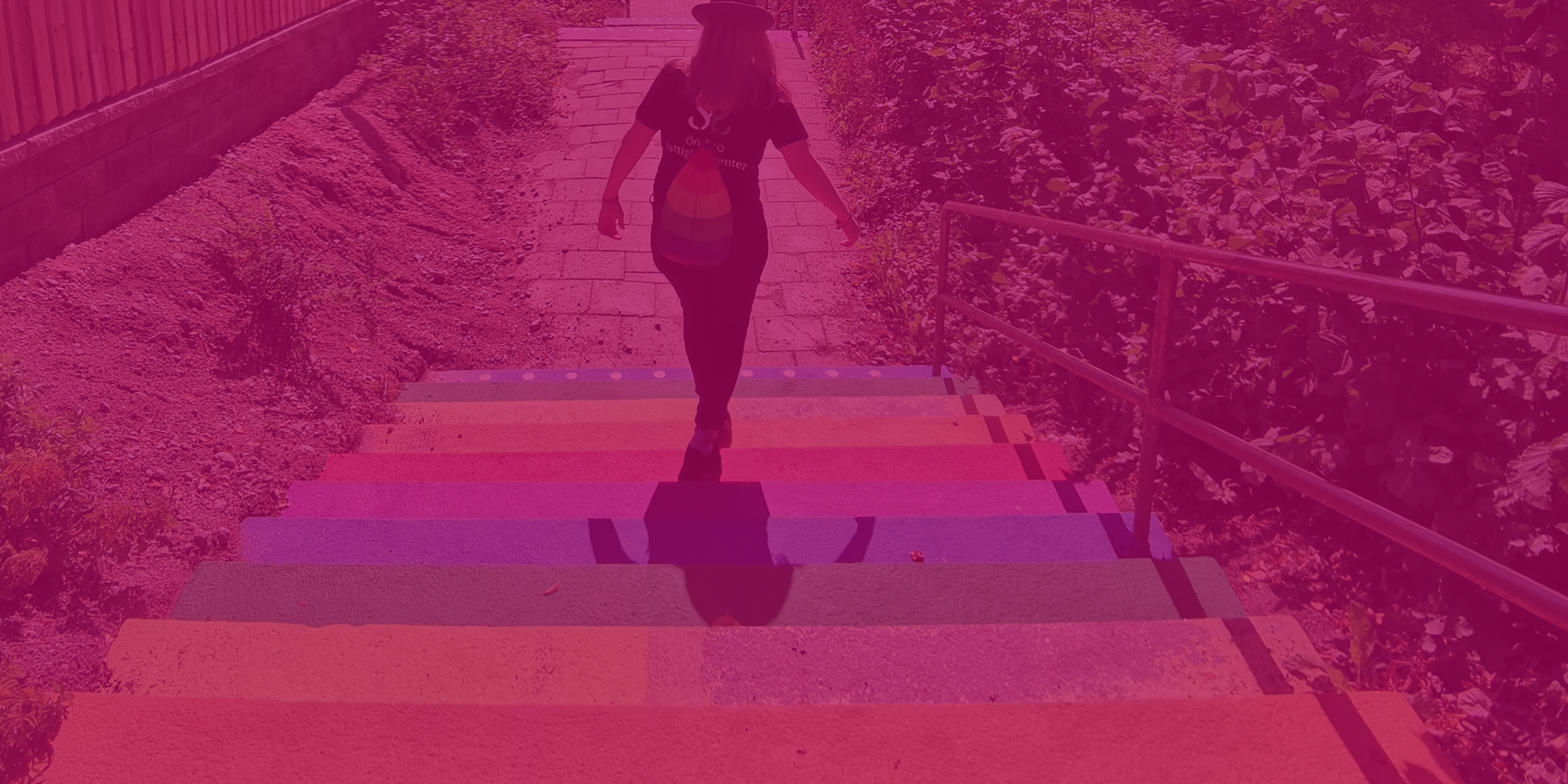 En person går ned för en regnbågsfärgad trappa